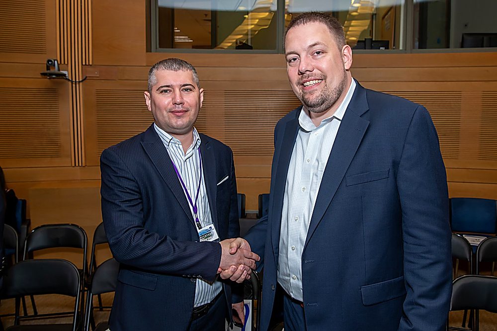 Gregg Roman shaking hands in a Knesset committee room
