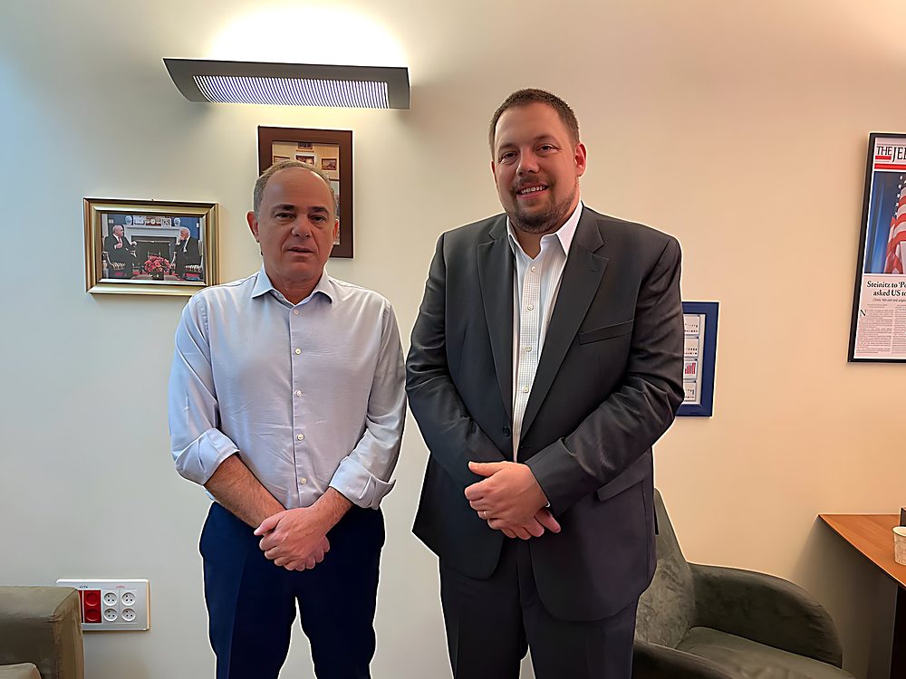 Gregg Roman standing beside former Israeli minister Yuval Steinitz in his office